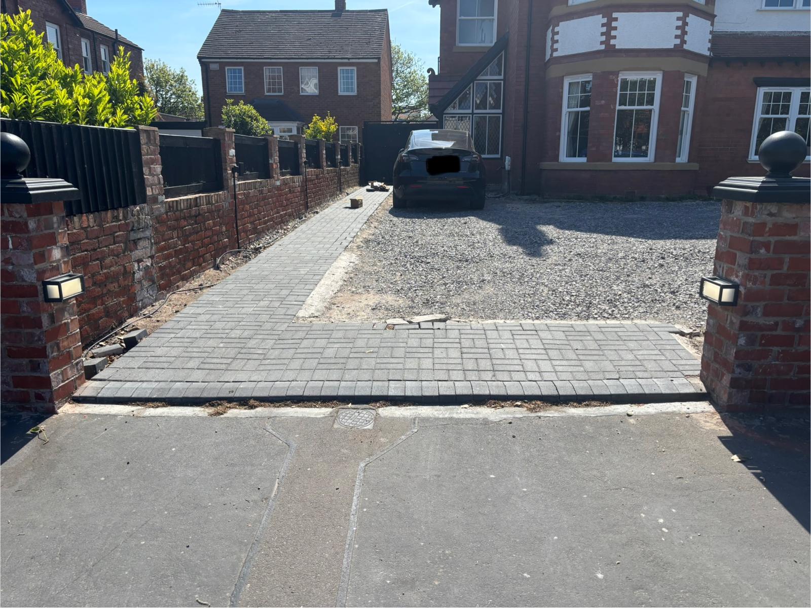 Completed driveway project showing block paving and perimeter lighting pillars — Wirral