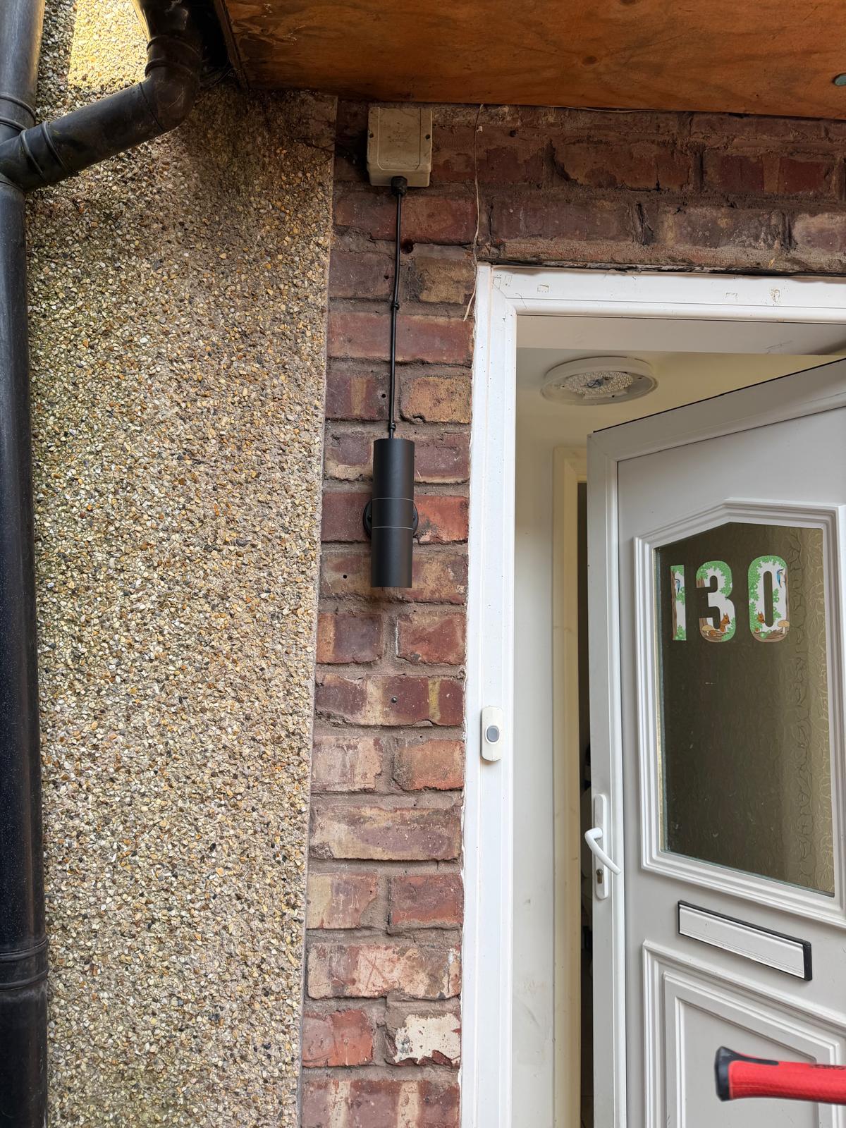 External pendant light fitting mounted beside a front door — Wirral